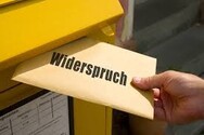 Briefkasten in den ein Umschlag mit der Aufschrift Widerspruch geschoben wird